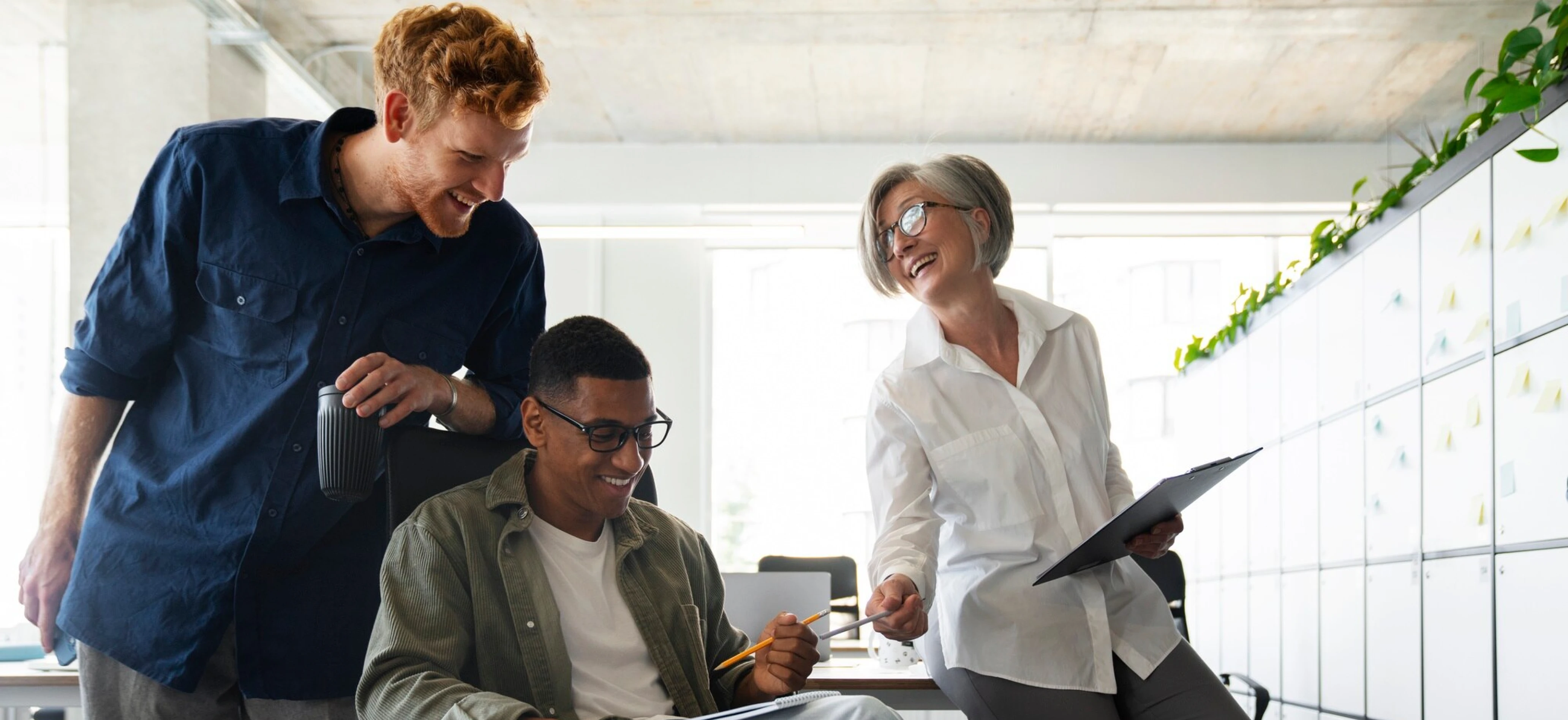 Team collaborating around a laptop in a bright office